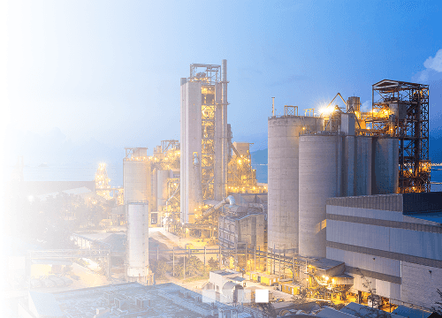 Grande instalação industrial com tanques, tubulações e luzes. 